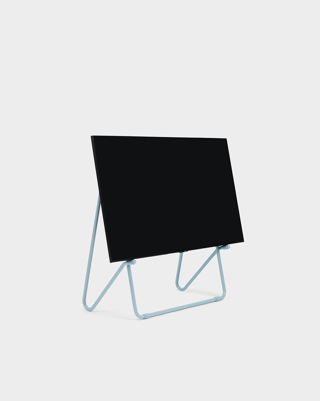 Bloom in Powder Blue low stand holding a black display panel, angled studio packshot on a light grey background